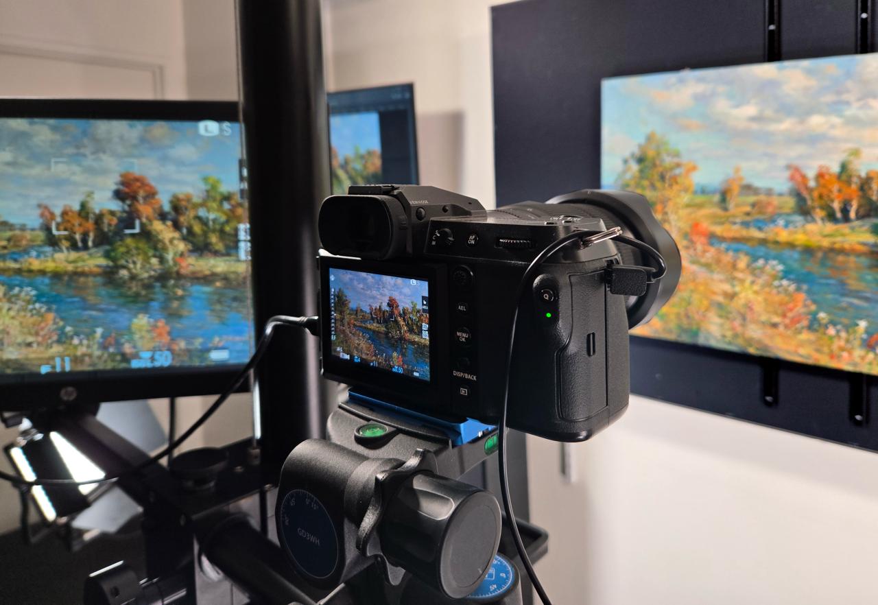 Camera tethered to monitor capturing painting in studio
